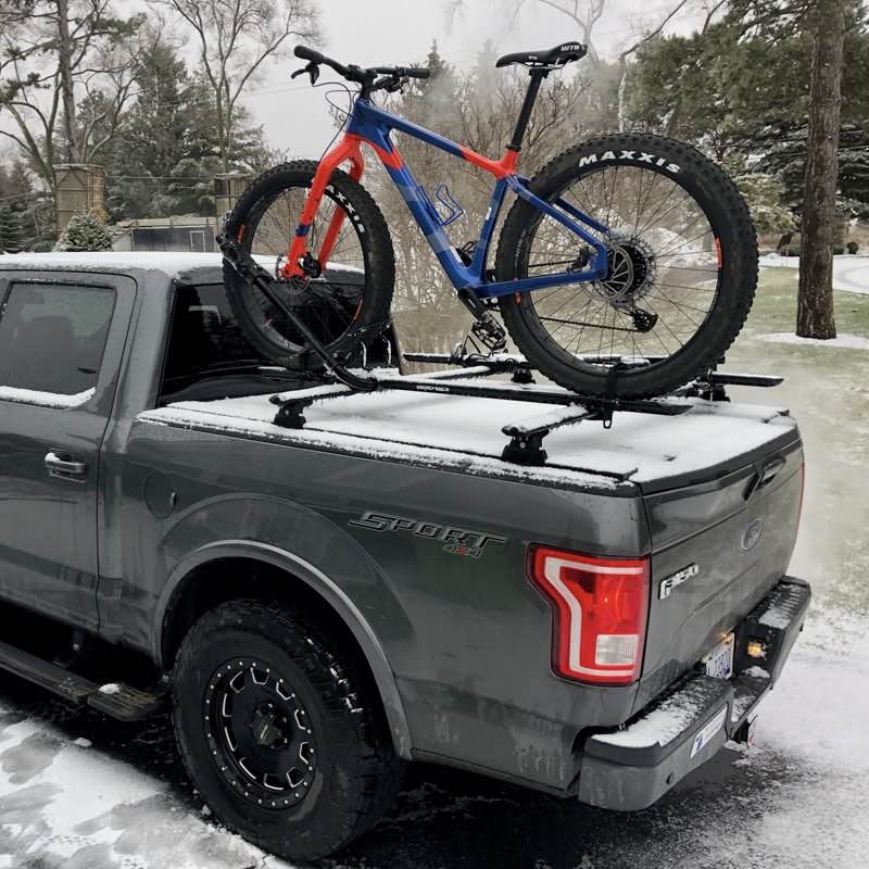 truck with bed cover holding a bike
